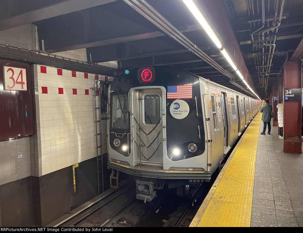 F train with R179 cars stopped at 34th Street-Herald Square Station